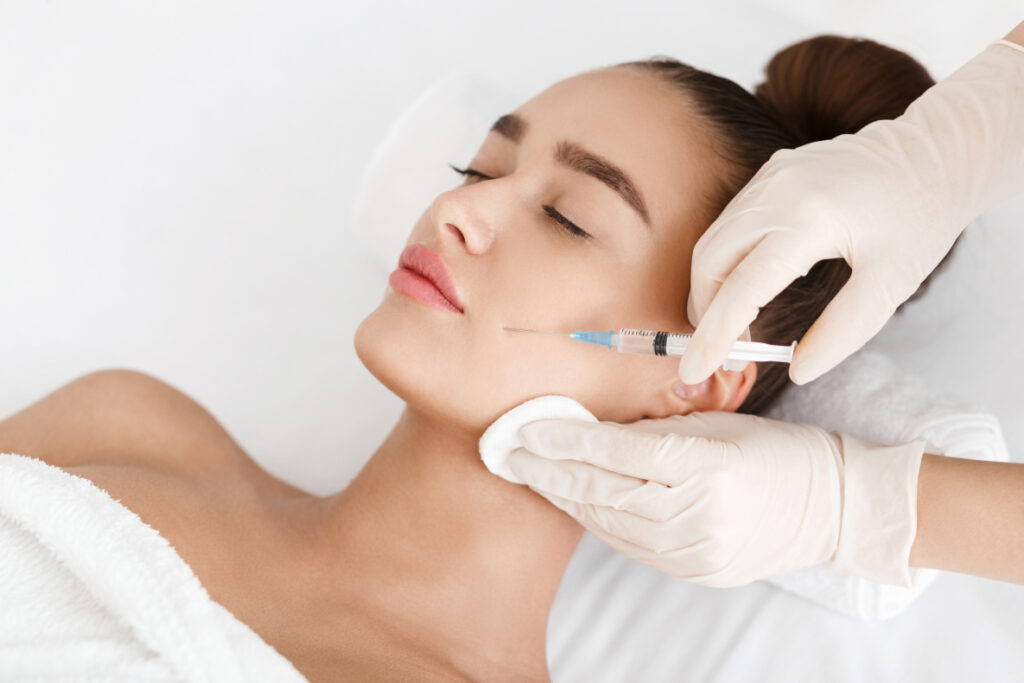 Woman receiving botox injection in cheek